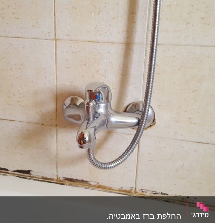 ברז אמבטיה עם צינור מקלחת על קיר קרמיקה